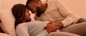 mujer embarazada y hombre sobre una cama