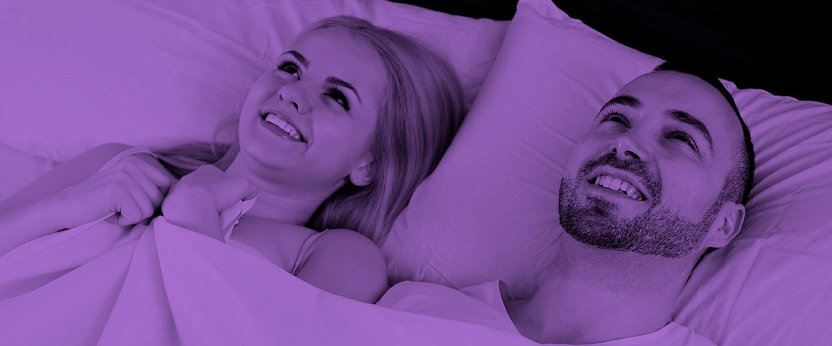 dos personas sonriendo en una cama